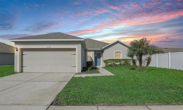 ranch-style home featuring a yard and a garage