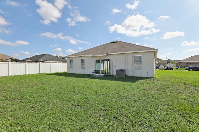 back of house with a yard and central AC unit