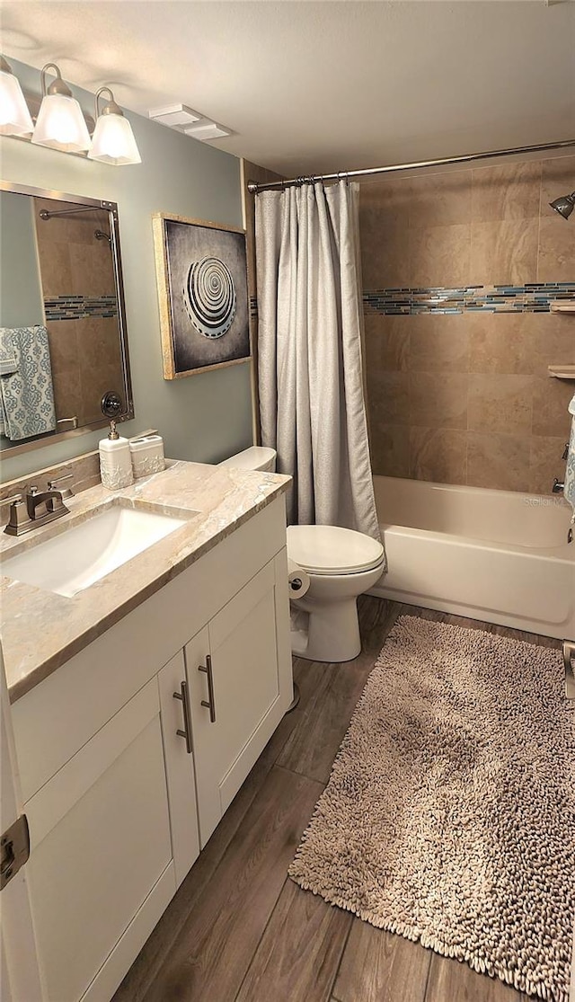 full bathroom with shower / bath combo with shower curtain, wood-type flooring, vanity, and toilet