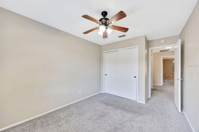 unfurnished bedroom with ceiling fan, a closet, and light carpet