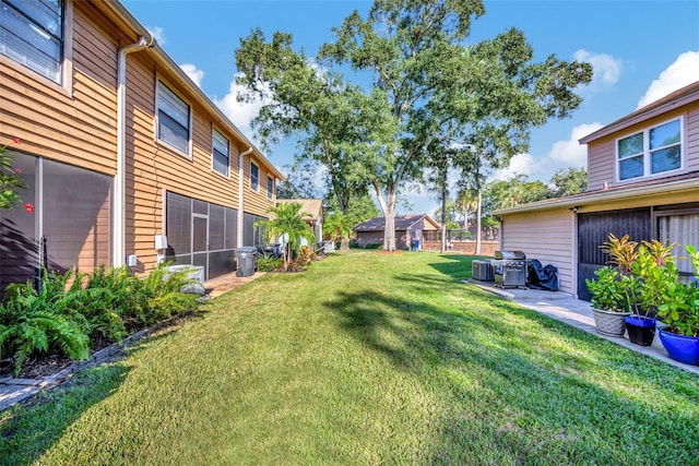 view of yard featuring a sunroom and a patio