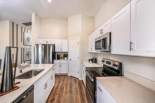 kitchen featuring stainless steel appliances, white cabinets, dark wood-type flooring, and sink