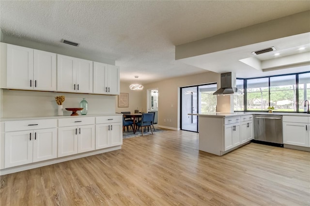 kitchen with white cabinets, kitchen peninsula, stainless steel dishwasher, light hardwood / wood-style flooring, and ventilation hood