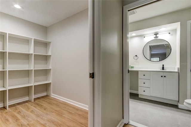 bathroom featuring wood-type flooring, vanity, and toilet