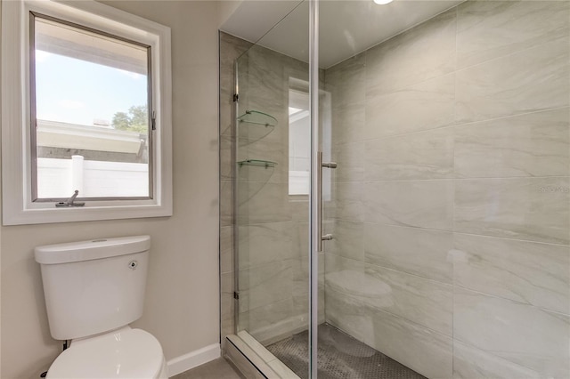 bathroom with a shower with shower door and toilet