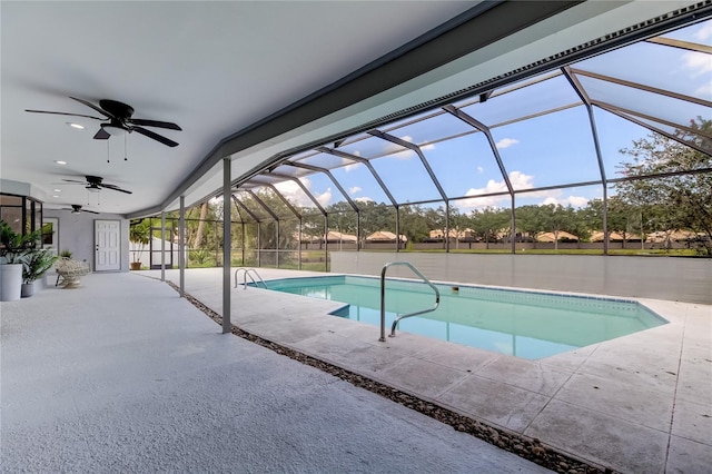 view of swimming pool featuring a patio, glass enclosure, and ceiling fan