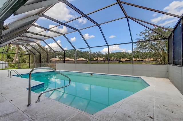 view of pool with glass enclosure and a patio