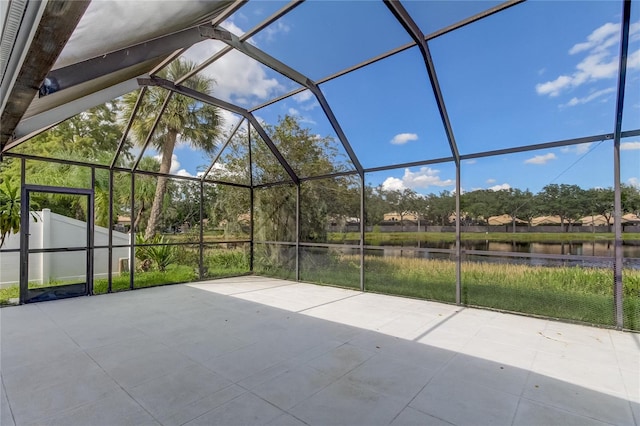 view of patio featuring a water view and a lanai