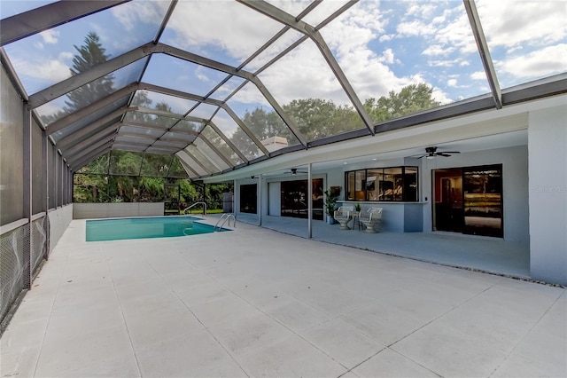 view of pool featuring glass enclosure, ceiling fan, and a patio area