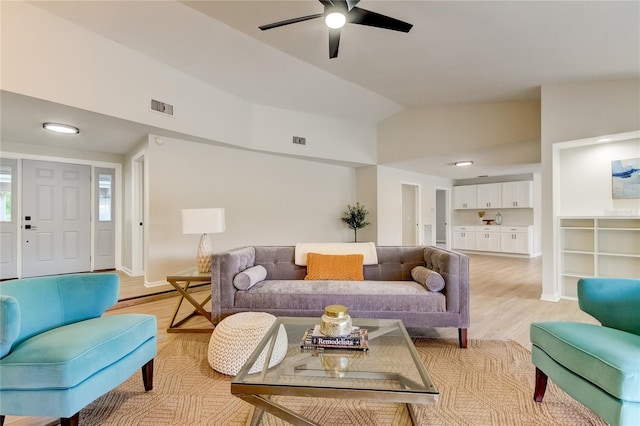 living room featuring vaulted ceiling, light hardwood / wood-style floors, and ceiling fan