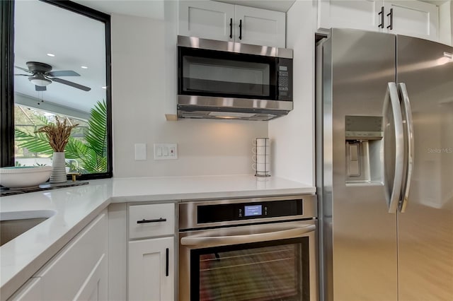 kitchen with ceiling fan, white cabinets, and appliances with stainless steel finishes