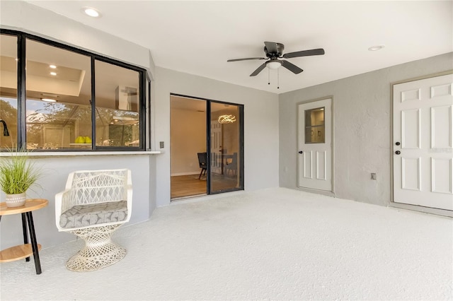 living area featuring ceiling fan and carpet flooring