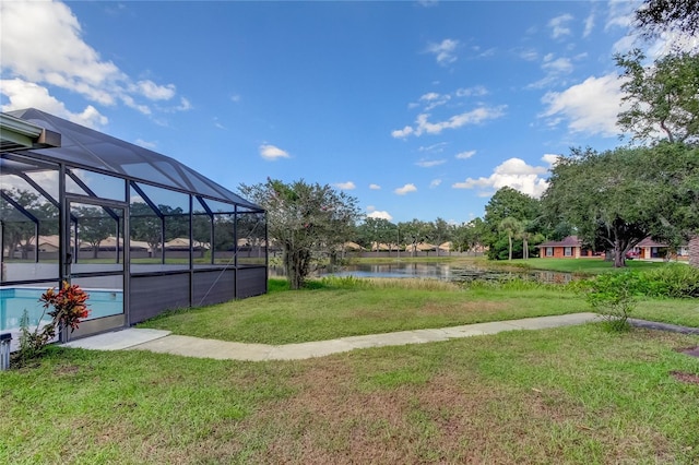 view of yard with a water view and glass enclosure