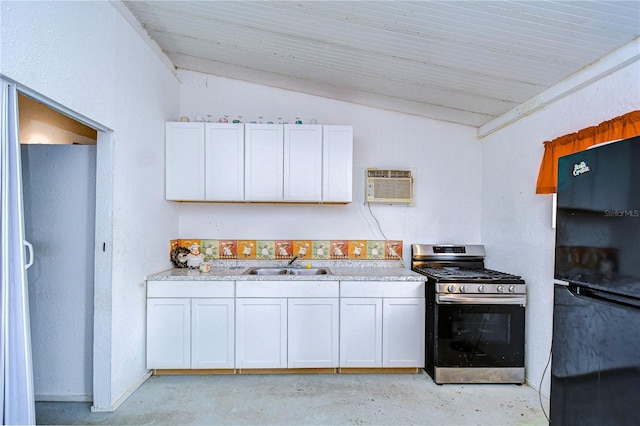 kitchen featuring sink, white cabinets, lofted ceiling, stainless steel gas stove, and black refrigerator