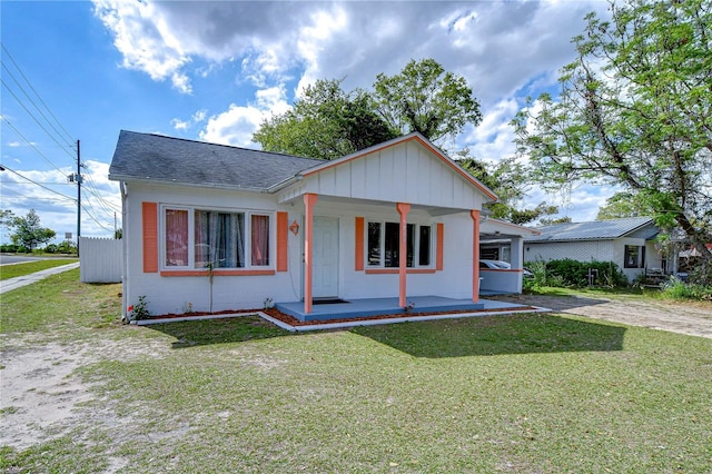 view of front of property with a front lawn, a porch, and a shingled roof