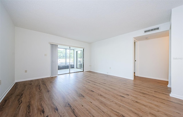 empty room featuring light hardwood / wood-style floors and a textured ceiling