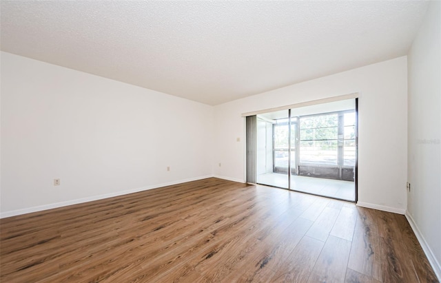 empty room with a textured ceiling and hardwood / wood-style floors