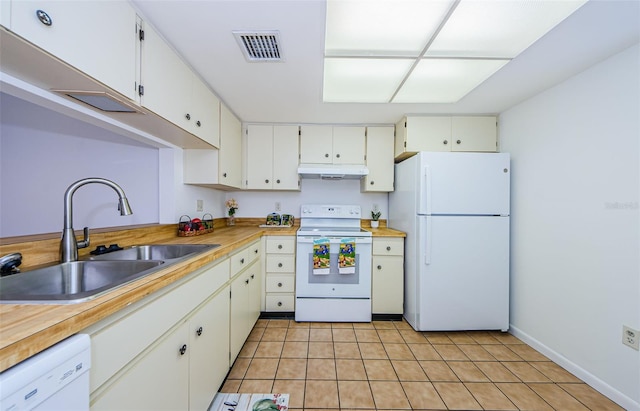 kitchen with white appliances, white cabinetry, light tile patterned flooring, and sink