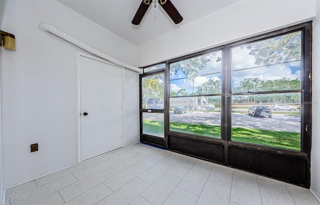 tiled empty room featuring ceiling fan