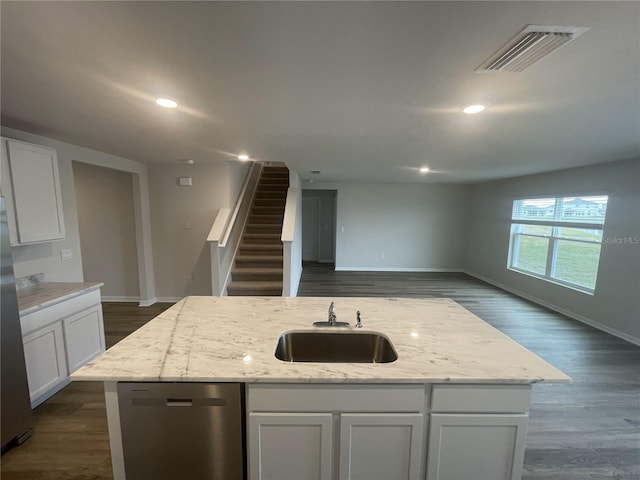 kitchen featuring a center island with sink, stainless steel dishwasher, white cabinets, and light stone countertops