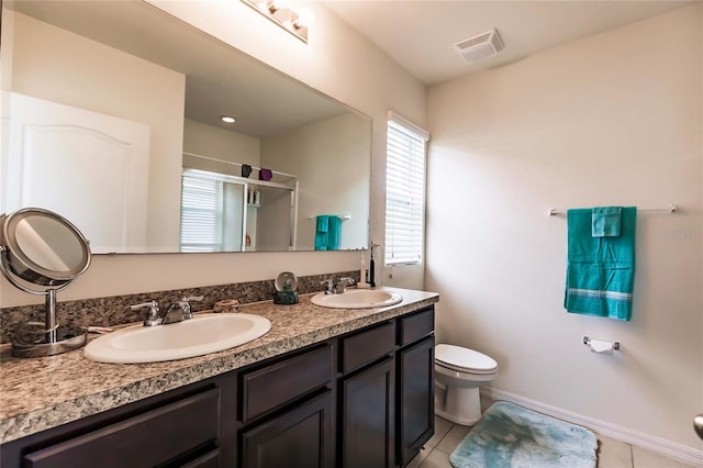 bathroom with tile patterned floors, vanity, toilet, and a shower with door