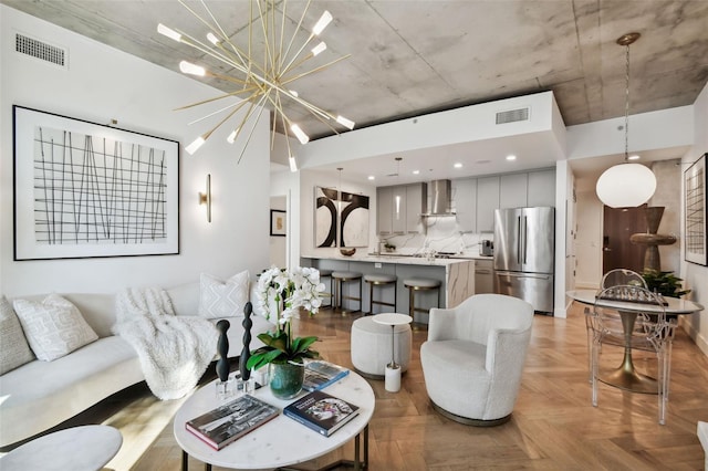 living room with a chandelier and light parquet flooring