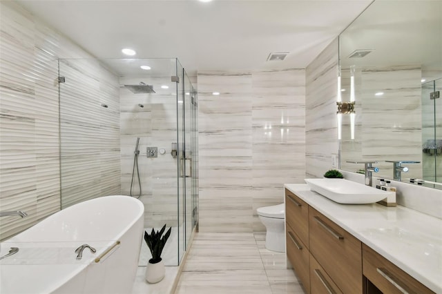 full bathroom with tile walls, vanity, toilet, and shower with separate bathtub