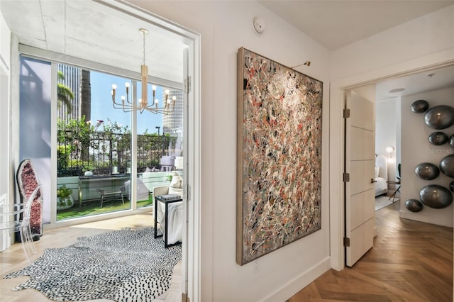 hallway featuring an inviting chandelier and parquet floors