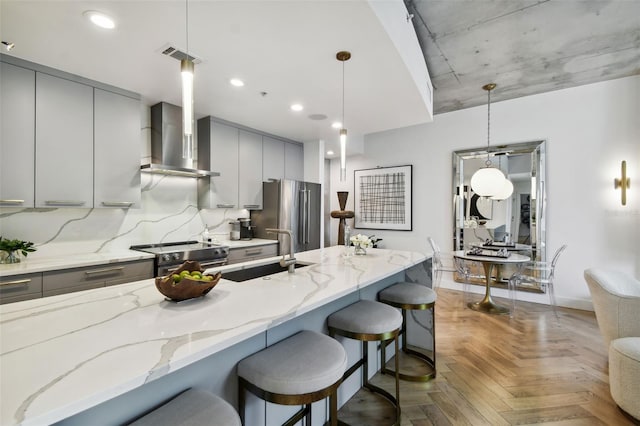 kitchen with pendant lighting, appliances with stainless steel finishes, sink, and a kitchen breakfast bar