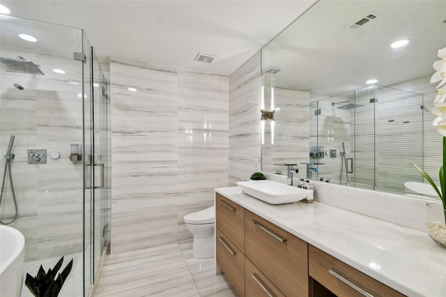 full bathroom featuring vanity, tile walls, shower with separate bathtub, and toilet