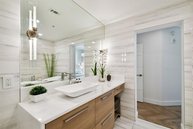 bathroom featuring vanity, tile walls, and parquet flooring