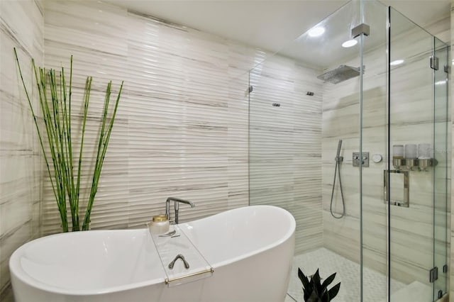 bathroom featuring tile walls and independent shower and bath