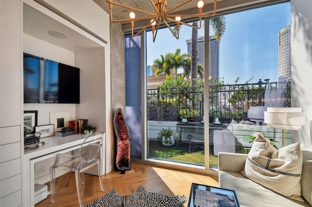 interior space with a wealth of natural light, a chandelier, and parquet flooring