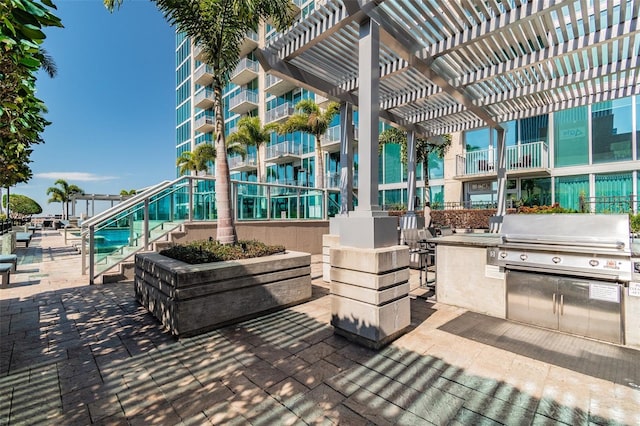 view of patio with a balcony, exterior kitchen, a pergola, and a grill