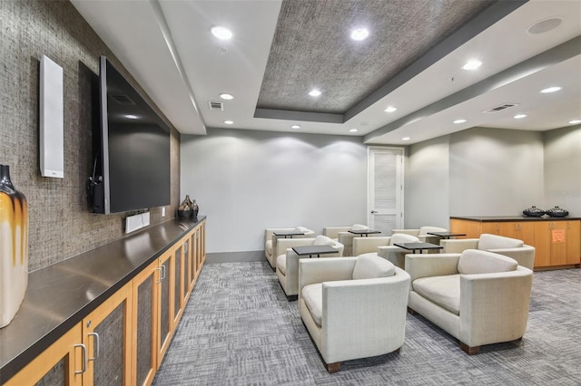 carpeted home theater with a tray ceiling