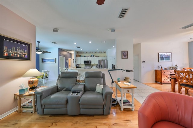 living room with light wood-type flooring and ceiling fan