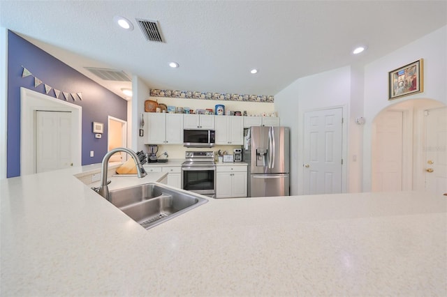 kitchen featuring white cabinets, a textured ceiling, stainless steel appliances, and sink