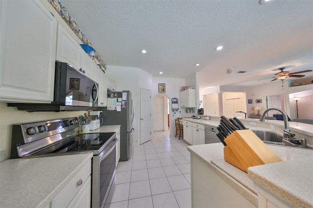 kitchen featuring appliances with stainless steel finishes, light tile patterned flooring, white cabinets, a textured ceiling, and ceiling fan