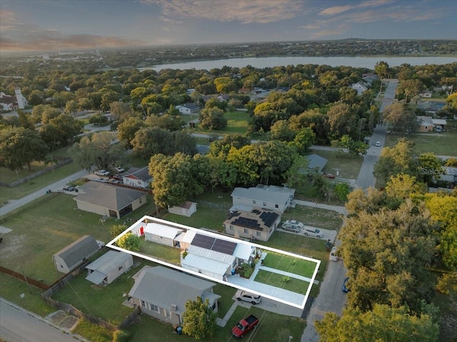 aerial view at dusk featuring a water view