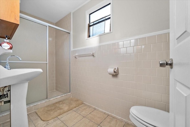 bathroom with walk in shower, tile walls, tile patterned flooring, and toilet