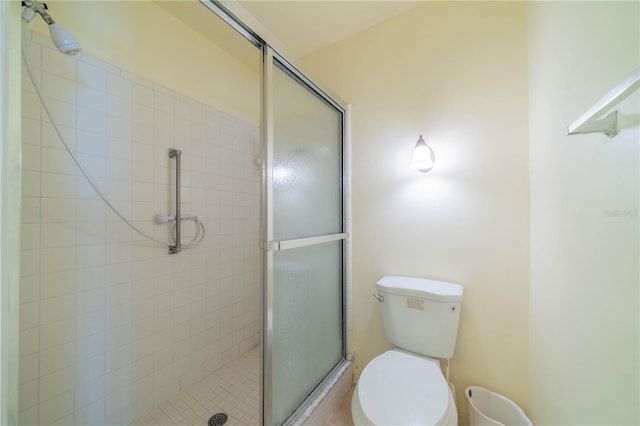 bathroom featuring toilet and an enclosed shower