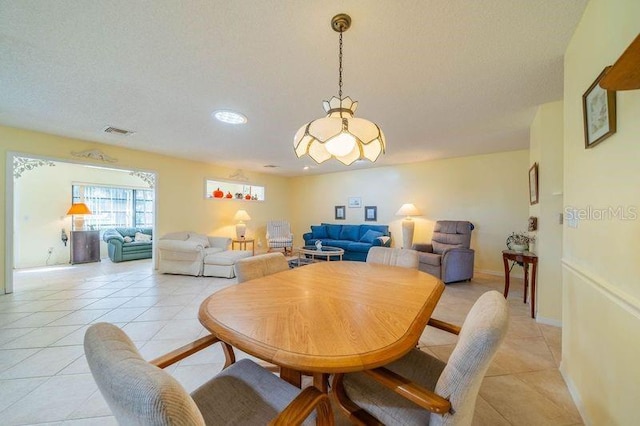 dining room featuring a textured ceiling and light tile patterned floors