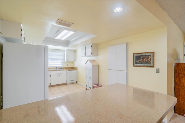 kitchen with white appliances, white cabinetry, light tile patterned flooring, and sink