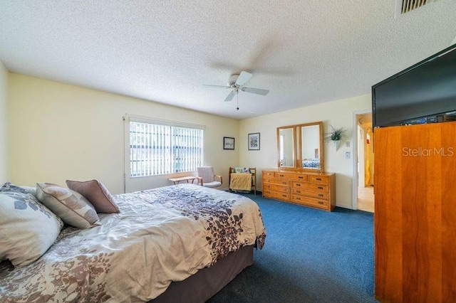 bedroom with dark carpet, ceiling fan, and a textured ceiling