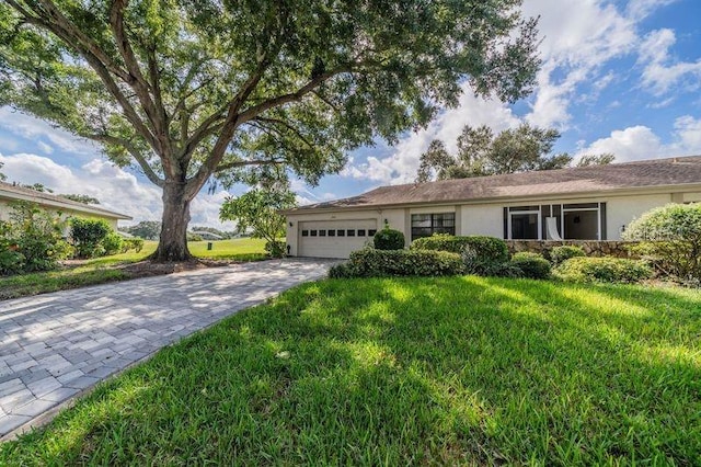 ranch-style house featuring a front lawn and a garage