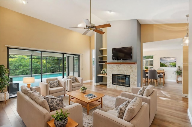 living room featuring light hardwood / wood-style flooring, ceiling fan, and high vaulted ceiling