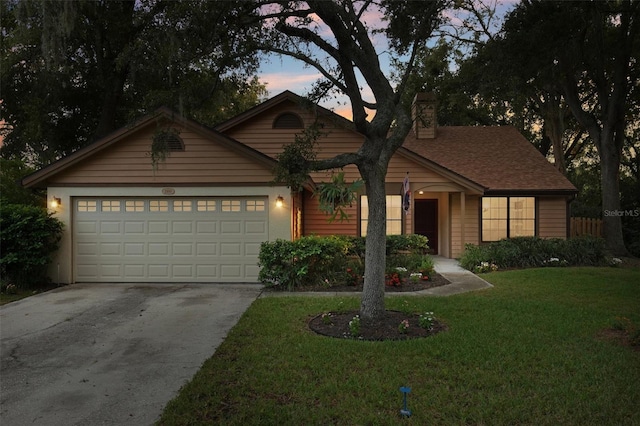 view of front of house with a garage and a yard