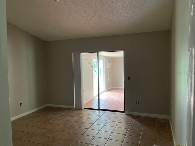 8602 Stoner Rd, Riverview, FL 33569 - empty room featuring light tile patterned flooring, a textured ceiling, and baseboards