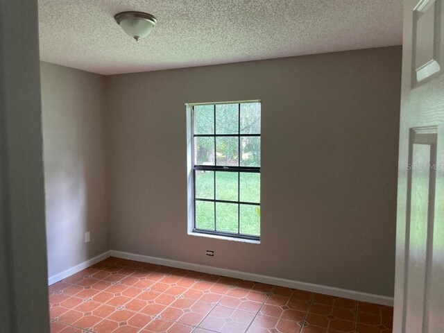 8602 Stoner Rd, Riverview, FL 33569 - unfurnished room featuring baseboards, tile patterned floors, and a textured ceiling