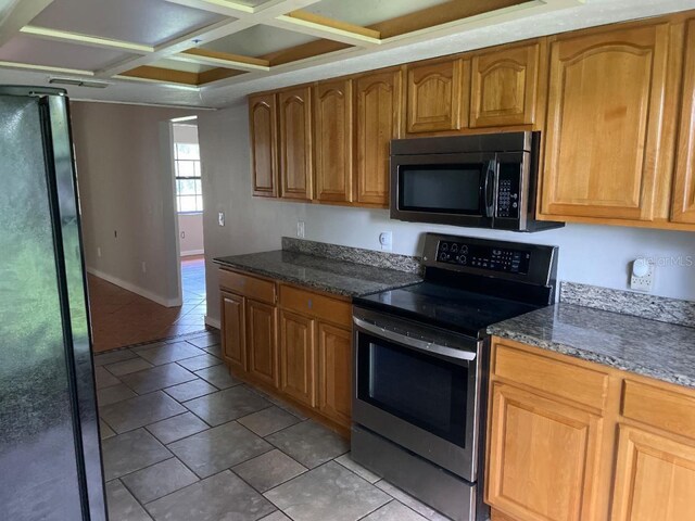 8602 Stoner Rd, Riverview, FL 33569 - kitchen with coffered ceiling, freestanding refrigerator, stainless steel electric range oven, and dark stone counters